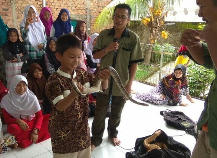 Salah seorang anak YAKIN sedang memegang seekor ular jenis piton, dan diberi penjelasan oleh komunitas Sriwijaya Animal Lovers